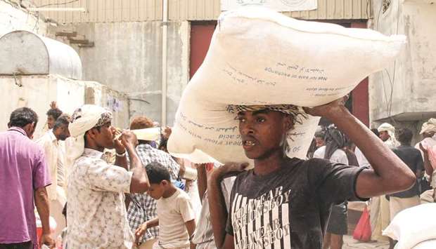 Yemeni civilians receive food aid for displaced people who fled battles in the Red Sea province of Hodeidah and are now living in camps in the northern district of Abs, under control by the Houthi rebels in Hajjah province, yesterday.