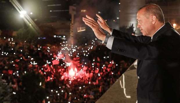 Turkish President Tayyip Erdogan waving to supporters gathered above a balcony at the headquarters of the AK Party in Ankara