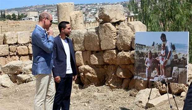 Britain's Prince William and Jordan's Crown Prince Hussein look at a photograph showing William's wife, Catherine, the former Kate Middleton, her father Michael and younger sister Pippa in the ruins of the Roman city of Jerash in the 1980s, in Jerash on Monday.