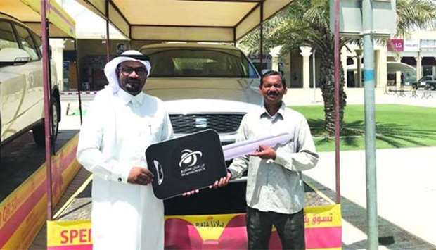 Ram Bujharat receives the car key from Salem al-Fouhaid, public and government relation manager of Ibn Ajayan Projects.