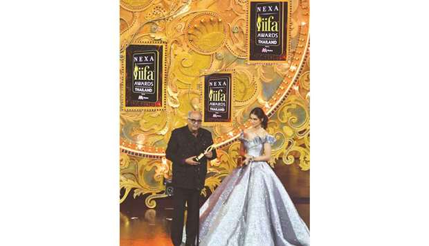 Boney Kapoor receives the award for best performance in a leading role u2013 female on behalf of his late wife Sridevi for her role in Mom as actress Kriti Sanon looks on during the IIFA Awards event in Bangkok.
