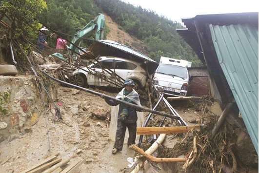 A paramilitary trooper clears debris of a landslide in Lai Chau province of Vietnam yesterday.
