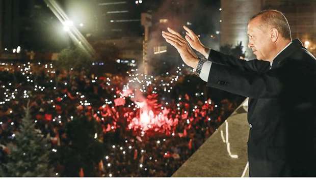 This handout picture released yesterday shows Erdogan waving to supporters from a balcony at the AKP headquarters in Ankara, late on Sunday as they celebrate his election victory.