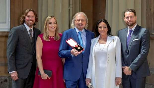 Singer and songwriter Barry Gibb poses with his wife, Linda and children Michael, Alexandra and Ashley after being knighted by Prince Charles at Buckingham Palace on Tuesday.