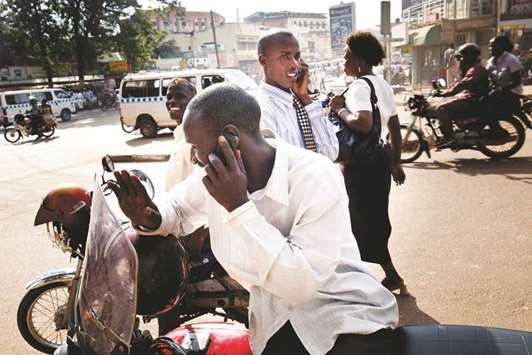 Men speak on their cell phones in Kampala, Uganda (file). Most analysts are convinced that Uganda, East Africau2019s third-largest economy, has great potential for Islamic banking as many Muslims u2013 who make up 14% of the countryu2019s 45mn population u2013 have avoided existing conventional lenders because they charge interest.
