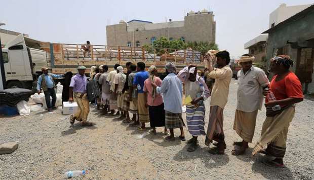 People displaced by the fighting near the Red Sea port city of Hodeidah queue to receive aid from United Nations agencies in Hodeidah, Yemen