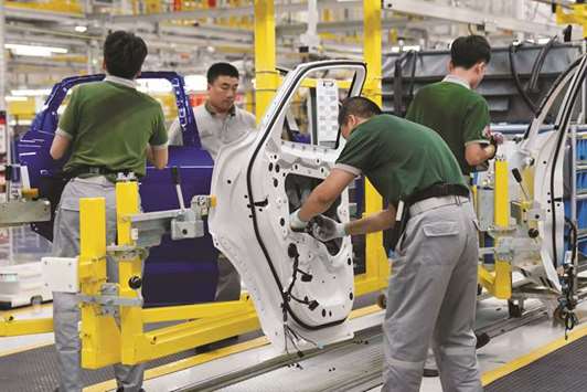 Employees work at the production line inside the Chery Jaguar Land Rover plant phase 2 after the opening ceremony in Changshu, Jiangsu province. The automaker, which already makes the gasoline-powered E-Pace compact sport utility vehicle locally with its Chinese partner Chery Automobile, will try to fully use its current capability in the Asian country to produce an EV, Murray Dietsch, president of the joint venture, said in an interview yesterday.