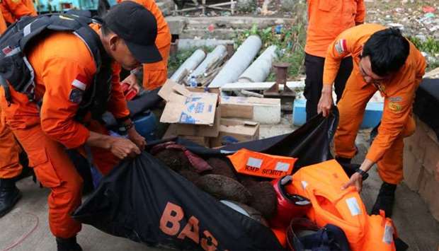 Search and rescue officers carry items they believe belonged to passengers from a ferry which sank last week