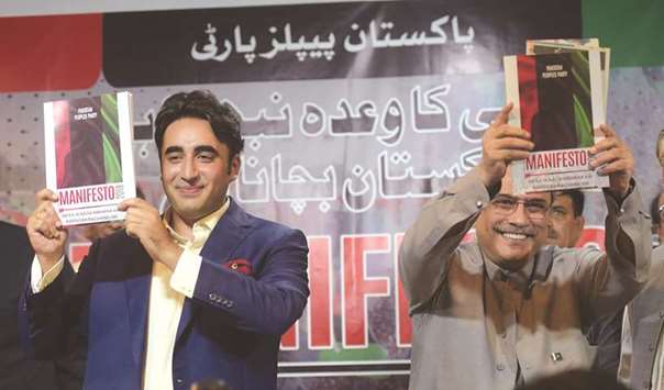 Party chiefs Bilawal Bhutto Zardari with his father, former president Asif Ali Zardari, display copies of their Pakistan Peoples Party (PPP) manifesto for the forthcoming general election during a press conference in Islamabad.
