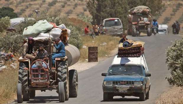 Syrians displaced by government forces' bombardment in the southern Daraa province countryside drive near the town of Shayyah, south of the city of Daraa, towards the border area between the Israeli-occupied Golan heights and Syria.