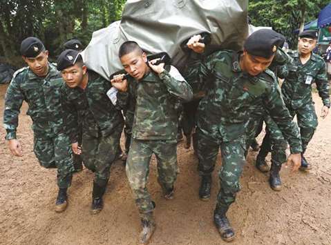 Soldiers unload aid supplies near the Tham Luang cave complex, as a search for members of an under-16 soccer team and their coach continues, in the northern province of Chiang Rai in Thailand yesterday.