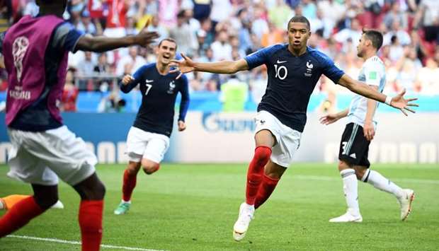 France's forward Kylian Mbappe (R) celebrates after scoring their third goal