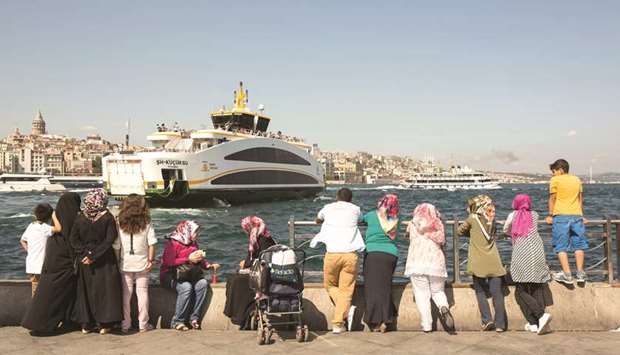 Pedestrians watch ferries on the Bosphorus straits in the Eminonu district of Istanbul (file). Turkey yesterday said it was addressing the concerns of financial markets about the economy after Moodyu2019s threatened a further downgrade of the rating on the ability of the government to pay back its debts.