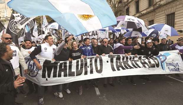 People shout slogans as they hold a banner that reads u2018Damned increase of utility tariffsu2019 during a demonstration in Buenos Aires on Friday.