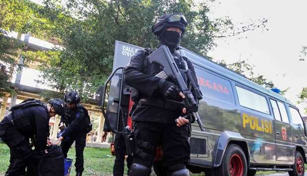 Indonesian anti-terrorism policeman holds a rifle as others seized crude bombs at Riau University building in Pekanbaru, Sumatra Island, Indonesia
