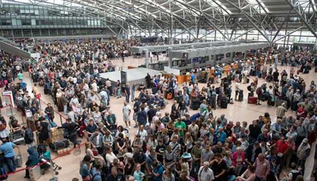 Travellers wait at Hamburg airport on Sunday as Germany's fifth busiest airport ground to a halt due to a power outage caused by a short circuit.