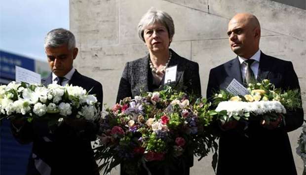 Britain's Prime Minister Theresa May, London's Mayor Sadiq Khan and Home Secretary Sajid Javid hold wreaths during commemorations of the first anniversary of the attack on London Bridge, in London on Sunday.