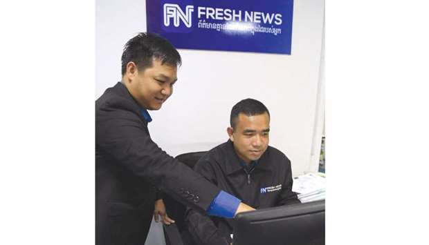 Cambodian online news outlet u2018Fresh Newsu2019 founder and chief executive officer Lim Chea Vutha, left, talking with a staff member in their newsroom in Phnom Penh.