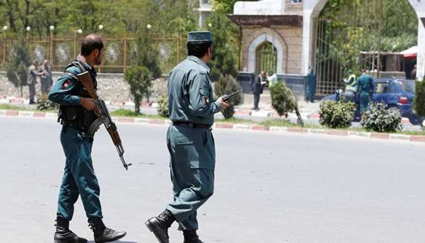 Afghan police officers keep watch at the site of a suicide attack in Kabul, Afghanistan