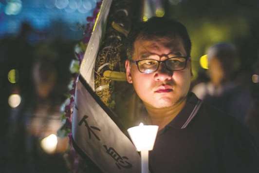 A man holds a candle during a vigil in Hong Kong yesterday.