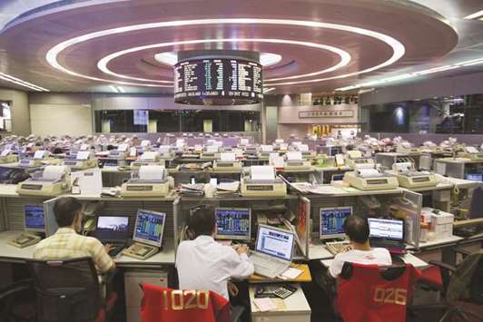 Traders work at the Hong Kong Stock Exchange. The Hang Seng closed up 0.3% to 31,093.45 points yesterday.