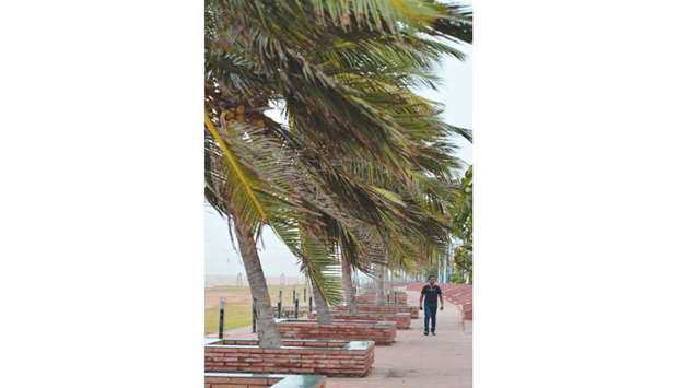A man walks at the Galle Face promenade during monsoon winds in Colombo yesterday.