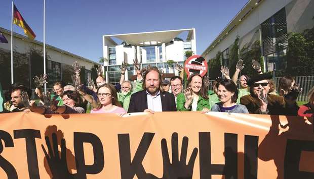 Politician of the Greens and member of the parliament Anton Hofreiter (centre) and environmental activists holding up their hands painted in black to call for the phasing out of coal energy in front of the Chancellery in Berlin yesterday.
