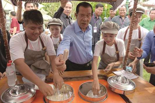Cambodian Prime Minister Hun Sen picks up an ice cream after taking part in an event to set a record for the worldu2019s longest scarf with the length of 1,000m in Phnom Penh yesterday.