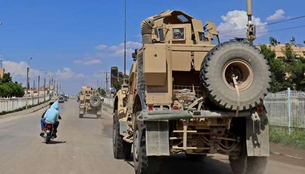 Vehicles from the US-led coalition battling the Islamic State group patrol the town of Rmelane in Syria's Hasakeh province on June 5, 2018.