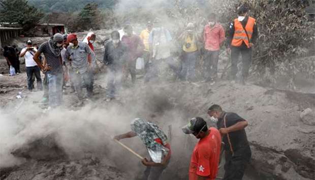 Members of a family search for missing relatives at an area affected by the eruption of Fuego volcano in San Miguel Los Lotes in Escuintla, Guatemala.