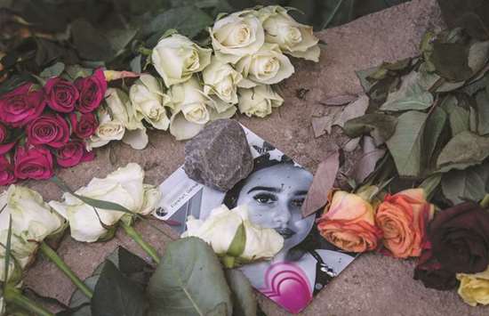 A picture of Susanna Maria Feldman is seen among flowers at a makeshift memorial at the site in Wiesbaden, Germany, where she was allegedly raped and murdered by an asylum-seeker.