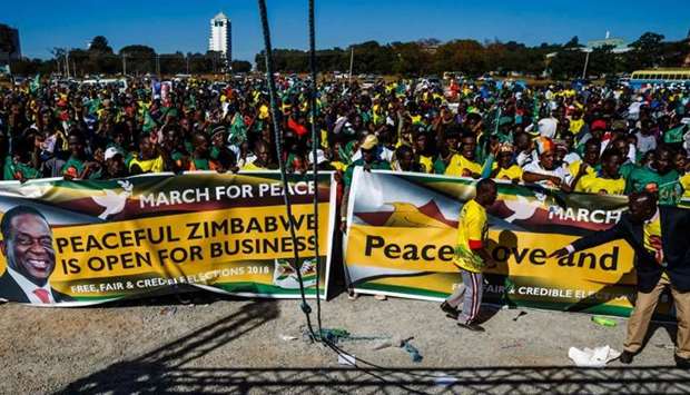 Activists from Zimbabwe's ruling party Zimbabwe African National Union Patriotic Front (ZANU PF) Youth League cheer as they march for peace ahead of the July 30 general elections
