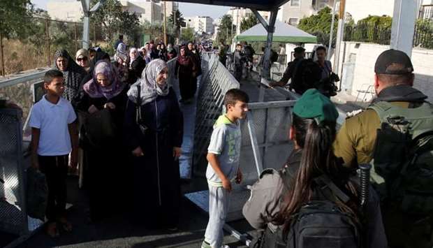 Palestinians make their way through an Israeli checkpoint