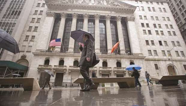 Pedestrians walk past the New York Stock Exchange (file). For years US inflation has been the dog that did not bark, but rising prices and wages are now showing signs of squeezing profit margins across corporate America, leading investors to punish companies whose results are deteriorating.