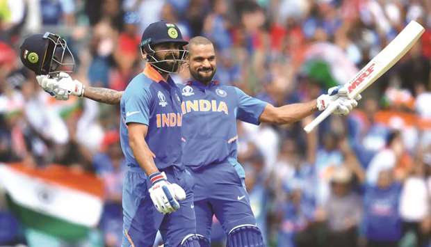 Indiau2019s Shikhar Dhawan (right) celebrates after scoring a century alongside captain Virat Kohli during the 2019 ICC Cricket World Cup match against Australia at The Oval in London yesterday. (AFP)