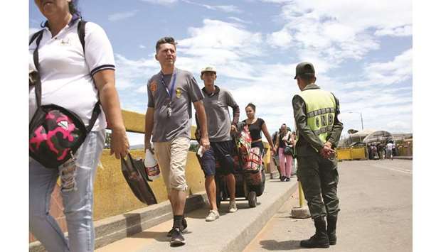 People cross the Colombian-Venezuelan border over the partially opened Simon Bolivar international bridge in San Antonio del Tachira yesterday.