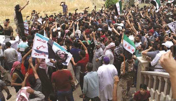 A picture taken yesterday shows Syrians waving rebel flags and portraits of Abdel-Basset al-Sarout during the funeral of the late rebel fighter in Al-Dana in the rebel-held Idlib region.
