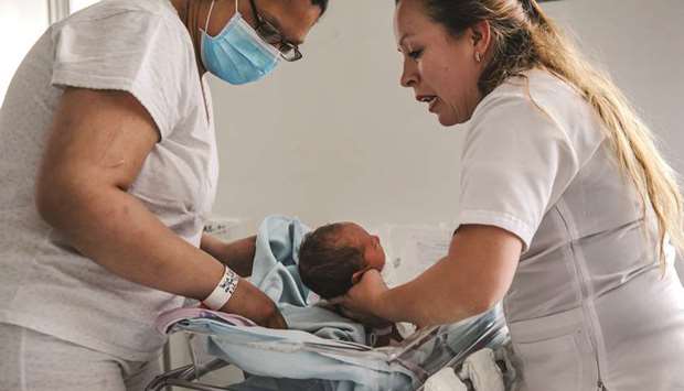 A MOTHER ON THE EDGE: Belys Torrealba Tovar, 24, left, reaches for her newborn, Angel, at the Hospital Materno Infantil in Bogota, Colombia. She hopes to return to Venezuela so he can have citizenship.
