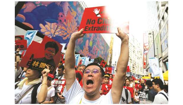 A demonstrator holds up a sign to demand authorities scrap a proposed extradition bill with China, in Hong Kong.