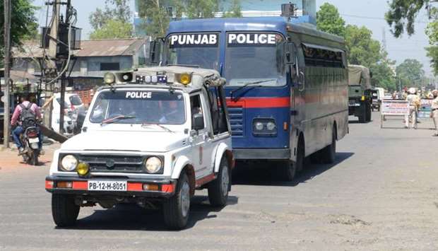 Indian Punjab Police personnel escort a police vehicle carrying the seven accused for the rape and murder of an eight-year-old nomadic girl in Kathua in Jammu and Kashmir, as verdict is expected to be delivered at the district court in Pathankot