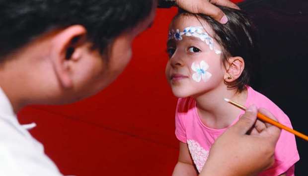 White flowers for a young girl enjoying face painting. PICTURE: Shaji Kayamkulam.