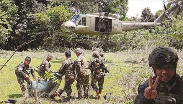 In this handout photo released by the Armed Forces of the Philippines-Joint Task Force Sulu yesterday, soldiers prepare to evacuate wounded and dead bodies as pursuit operations continue in Patikul of the province of Sulu.