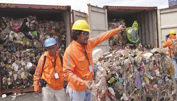 File photo shows Customs officials inspecting cargo containers with tonnes of garbage shipped by Canada at Manila port.
