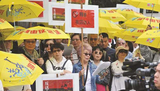 Demonstrators hold signs and yellow umbrellas as they gather in front of the Chinese Consulate in Vancouver, Canada, on Sunday to protest against a controversial extradition law proposed by Hong Kongu2019s pro-Beijing government to ease extraditions to China.