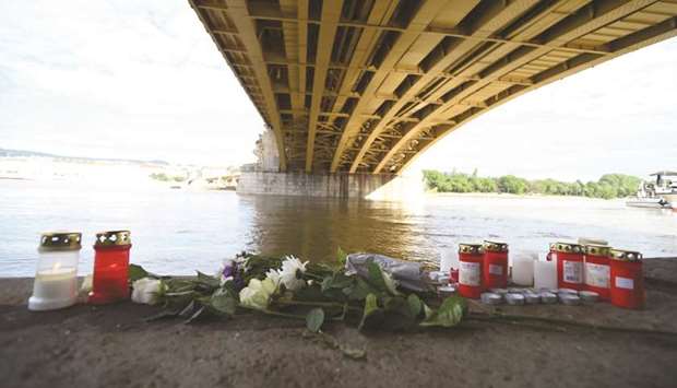 Flowers and candles are seen on the banks of the river Danube in Budapest, at the spot of a boat accident with seven dead and 21 people still missing, most of them South Korean tourists.