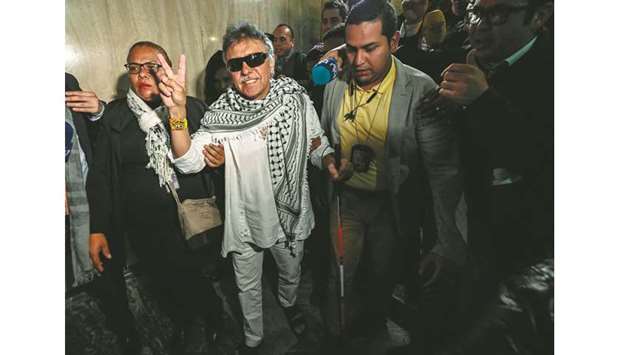 Common Alternative Revolutionary Force (Farc) party member Jesus Santrich (centre), wanted by the US for drug-trafficking, flashes the u201cVictoryu201d sign after swearing in as congressman in Bogota yesterday.