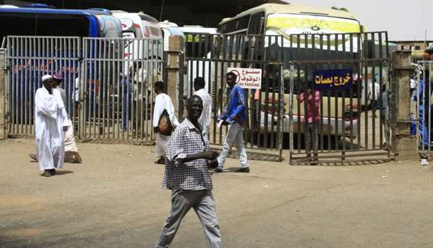 People walk past at the main bus station in Khartoum, linking the Sudanese capital with various parts of the country.