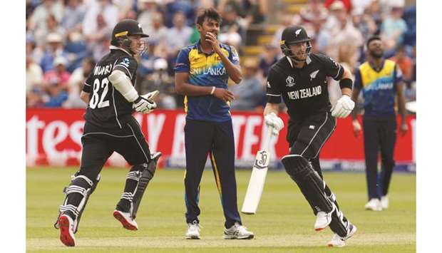 Sri Lankau2019s Suranga Lakmal (centre) watches the ball as New Zealandu2019s Colin Munro and Martin Guptill (right) run between the wickets during the 2019 ICC Cricket World Cup match in Cardiff yesterday. (Reuters)