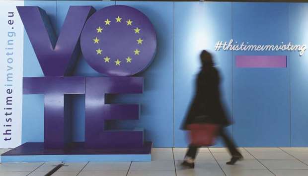 A woman walks past an advertising board for the EU elections at the Schuman railway station near the European Parliament in Brussels, Belgium, in this May 22 photograph.