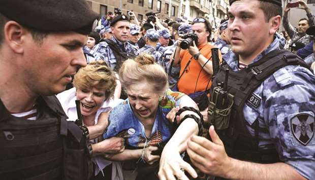 Russian police officers detain protesters during a march in central Moscow yesterday to protest against the alleged impunity of law enforcement agencies.